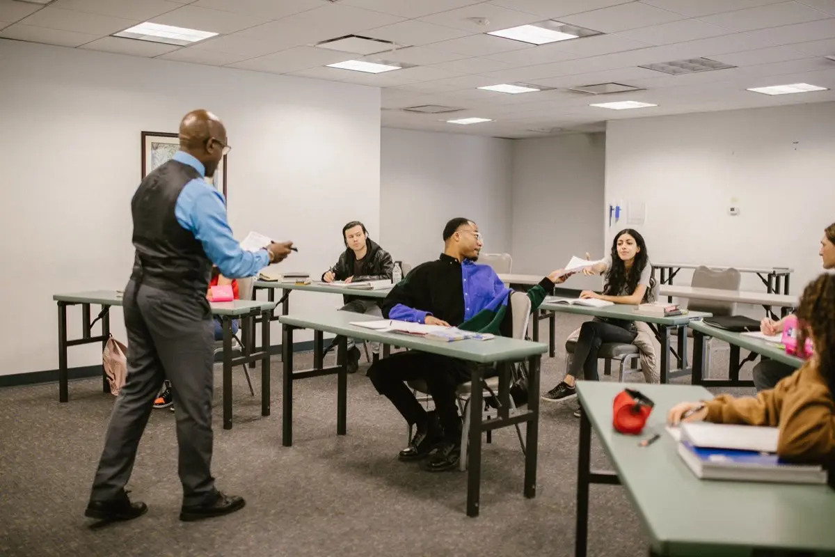 An instructor teaching a class of adult students in a training room